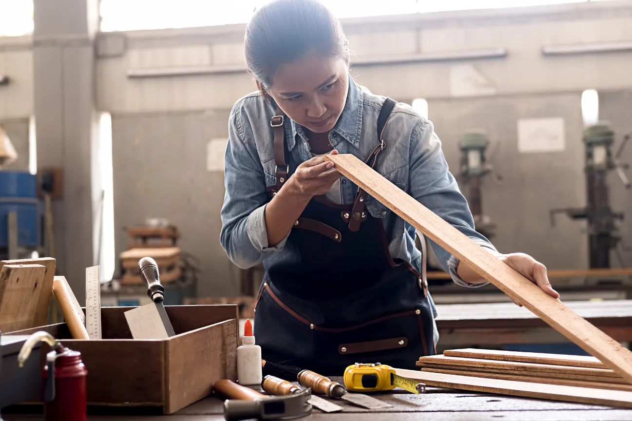 Skilled craftswoman inspecting timber as part of the about us story at Deck Builders Taupo.