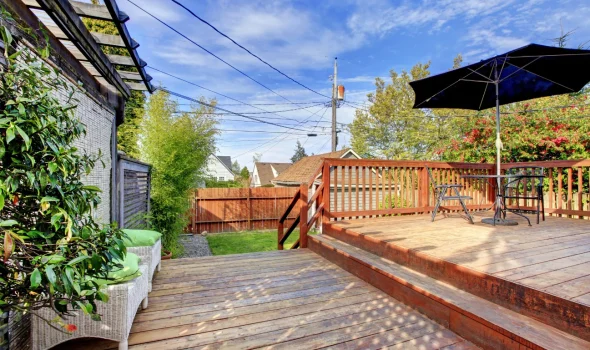 Outdoor wooden deck with seating and umbrella showing lasting value of custom decks by Deck Builders Taupo.