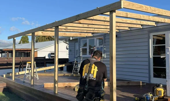 Builder working on a timber frame, showing trusted workmanship in custom decks by Deck Builders Taupo.